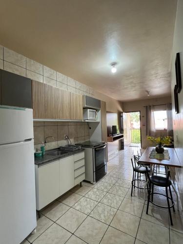 a kitchen with a table and a white refrigerator at Apartamento aconchegante no centro de Toledo in Toledo