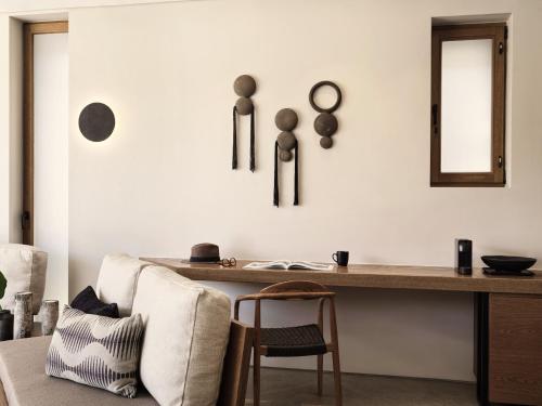 a living room with a desk and a chair at Magma Resort Santorini, In The Unbound Collection By Hyatt in Vourvoulos