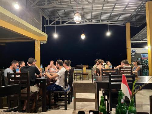 a group of people sitting at tables in a restaurant at Rinjani Golden in Senaru