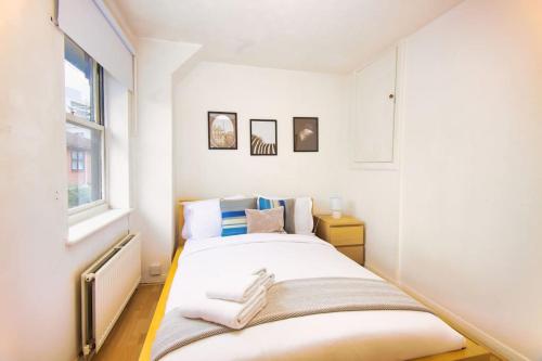 a bedroom with a bed with towels on it at Two Bed House near Kings Cross in London