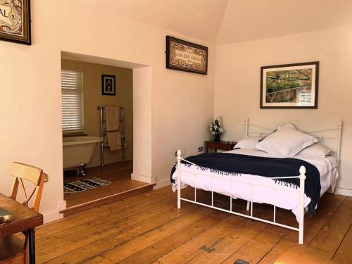 - une chambre avec un lit et une baignoire dans l'établissement Smugglers Lodge at Ventnor Botanic Garden, à Ventnor