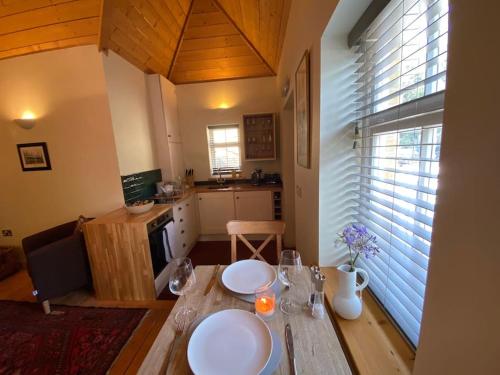 a kitchen with a wooden table with glasses on it at Smugglers Lodge at Ventnor Botanic Garden in Ventnor