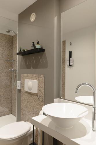 a bathroom with a white sink and a toilet at Paragon Apartments in Frankfurt/Main