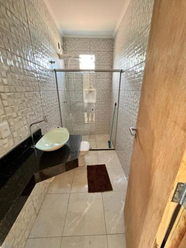 La salle de bains est pourvue d'un lavabo et d'une douche. dans l'établissement Luz girassol, à Santa Cruz Cabrália