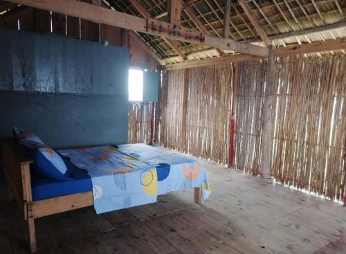 a bedroom with a bed in a straw building at Cabañas sobre el mar en San Blas Narasgandub. in Nusatupo