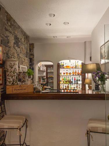 a bar in a restaurant with a counter and chairs at La Meridiana ReIais & Chateaux in Garlenda