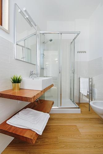 a bathroom with a glass shower and a sink at LuxAttico Bed & Breakfast in Lecce
