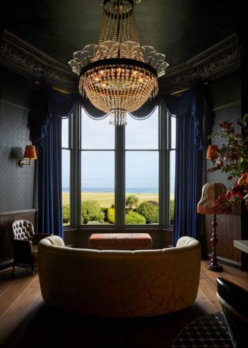 a living room with a chandelier and a large window at Marine North Berwick in North Berwick