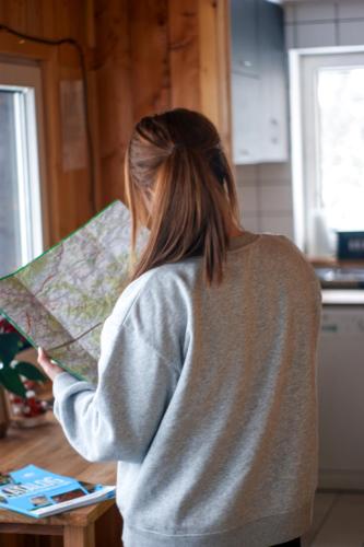 a woman holding a map in a kitchen at Domki na Widoku in Lubomierz