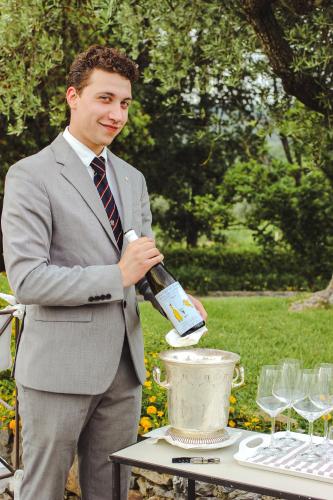 a man in a suit pouring a bottle of wine at La Meridiana ReIais & Chateaux in Garlenda