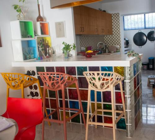 a kitchen with three bar stools and a counter at Villa Jo - stunning front line beach house. in L'Ametlla de Mar