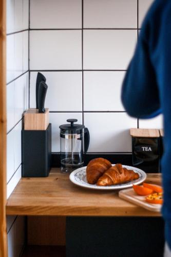 a table with a plate of croissants and a plate of bread at Domki na Widoku in Lubomierz