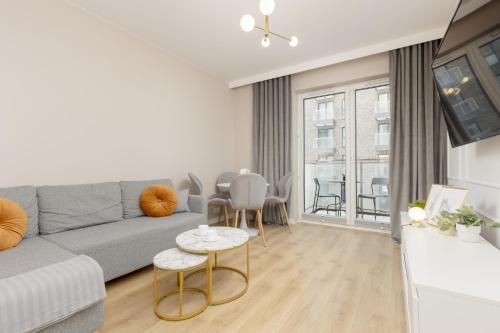 a living room with a couch and a table at White & Gold Marble Apartment Łódź Fabryczna by Renters in Łódź