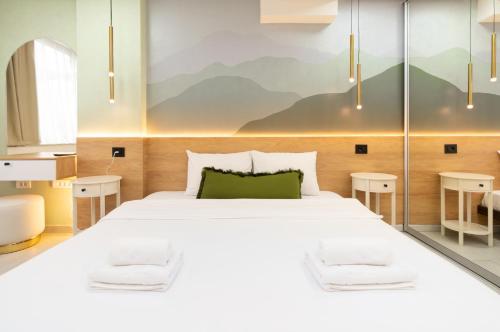 a bedroom with a large white bed and two tables at 7 Hills Rooms in Podgorica