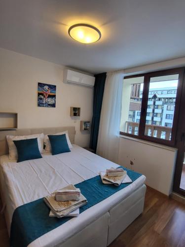 a bedroom with a large white bed with blue pillows at Beautiful Apartment in Bansko