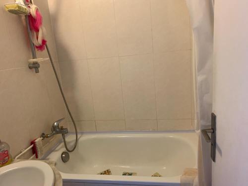 a small bathroom with a tub and a toilet at Une Chambre simple accès direct Aéroport d'Orly T4 in Orly