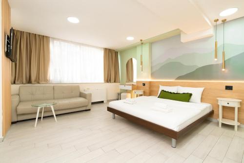 a hotel room with a bed and a couch at 7 Hills Rooms in Podgorica