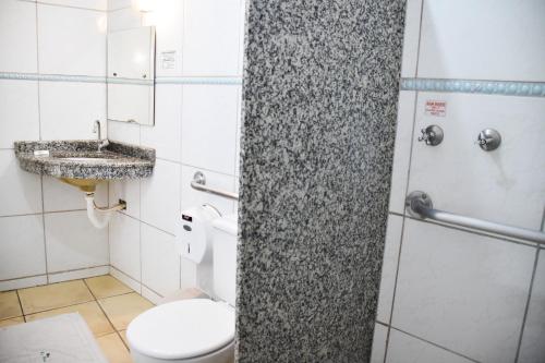 a bathroom with a toilet and a sink at Hotel Casa Nova in Várzea Grande