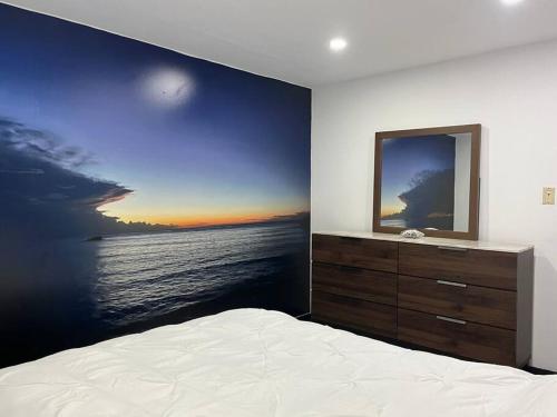 a bedroom with a large painting on the wall at Huellas in Arecibo