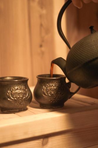 two black cups sitting on a table with a pot at Domki na Widoku in Lubomierz