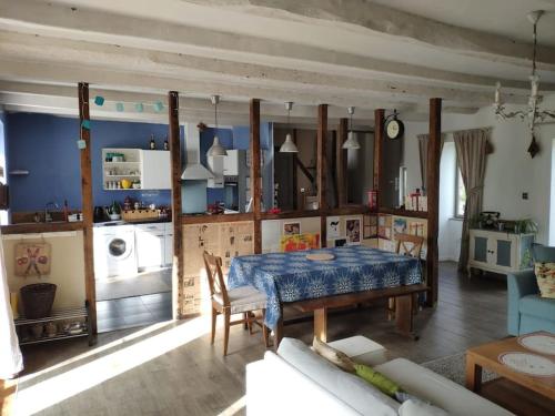 un salon avec une table et une cuisine dans l'établissement Gîte à proximité d'un château, à Les Portes du Coglais