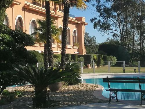 - un bâtiment avec un banc à côté d'une piscine dans l'établissement Bel appartement pour 6 personnes avec vue sur le Golfe de St Tropez, à Saint-Raphaël