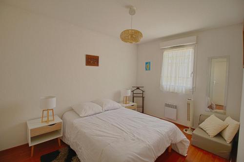 une chambre avec un lit blanc et un canapé dans l'établissement Appartement Capo Rosso sanguinaires Ajaccio, à Ajaccio