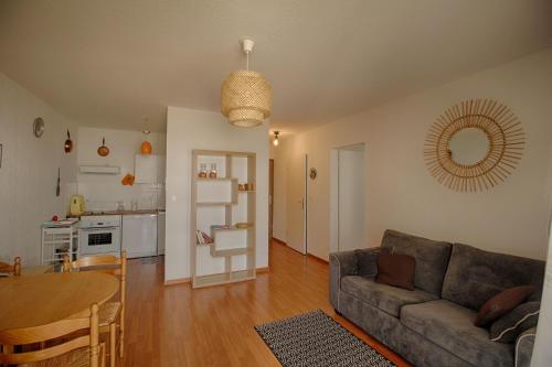 un salon avec un canapé et une table et une cuisine dans l'établissement Appartement Capo Rosso sanguinaires Ajaccio, à Ajaccio