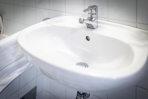 a white sink with a faucet in a bathroom at CALM & CONNECTED by JR City Apartments in Vienna