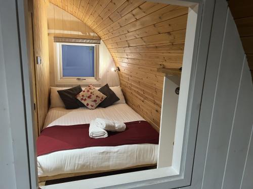a small bed in a small room in a tiny house at Mountain Edge Resort Mega pod 3 with Hot Tub in Church Stretton