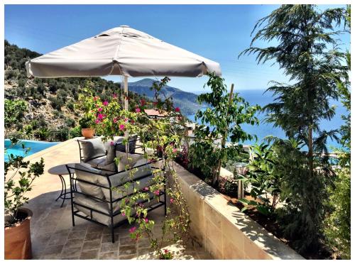 un patio con ombrellone, tavolo e sedie di Villa Valo a Kalkan