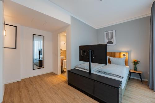 a bedroom with a black bed and a mirror at Nena Apartments Berlin Adlershof in Berlin