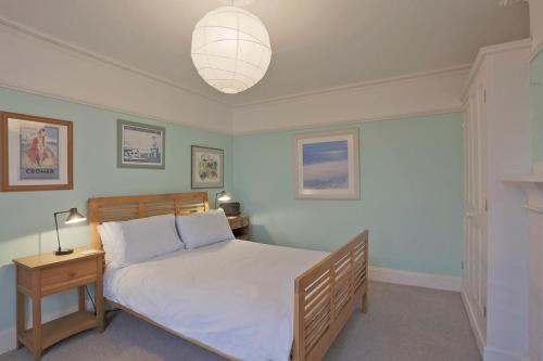 a bedroom with a large bed and a lamp at 10a East Cliff in Southwold
