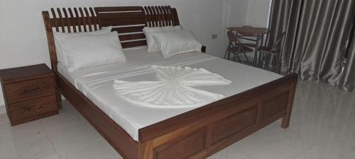 a bedroom with a bed with a wooden headboard at Kingson Hotel in Dar es Salaam