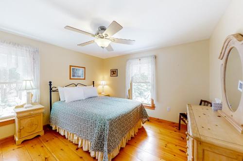 a bedroom with a bed and a ceiling fan at Chez Normand in Jefferson