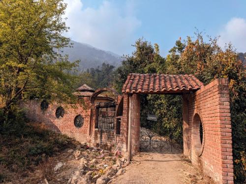 an entrance to a brick wall with a gate at Unique Mud Home With Scenic Mountain Views in Nainital