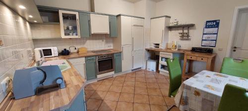 a large kitchen with white cabinets and green appliances at Ferienwohnung Auf der Höhe in Drüsedau