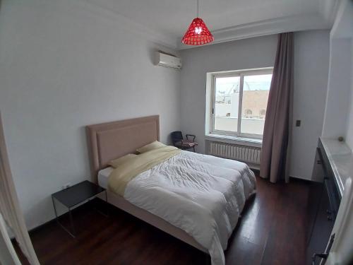 um quarto com uma cama e uma luz vermelha em Sunny Inn Les berges du lac 1 em Tunes