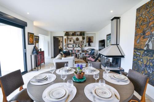 une salle à manger avec une table, des chaises et une cheminée dans l'établissement Cajan - Appt à 100m de la plage, à Langrune-sur-Mer