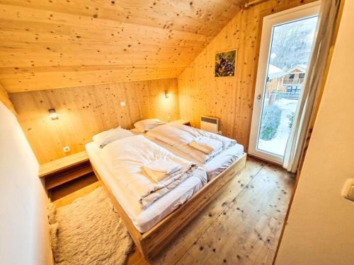 a large bed in a wooden room with a window at Kreischberg 14b - Chalet direkt am Skilift in Sankt Lorenzen ob Murau
