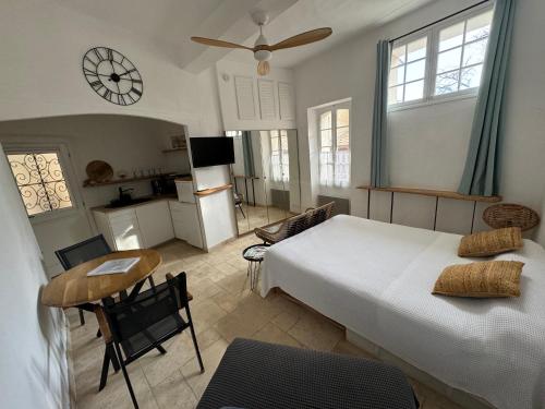 a bedroom with a bed and a kitchen with a clock at Studio 3 pers coeur de village Bormes les Mimosas in Bormes-les-Mimosas
