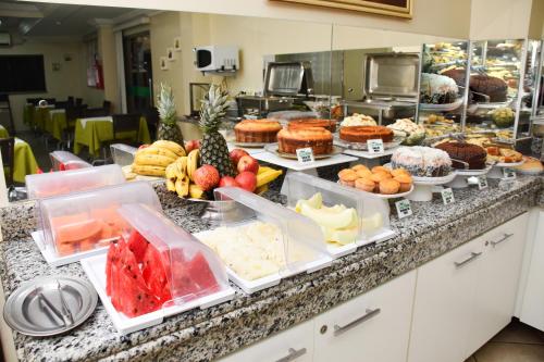 a buffet filled with different types of food on a counter at Hotel Casa Nova in Várzea Grande
