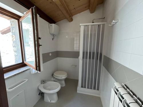 a white bathroom with a toilet and a window at Il Borgo dei Normanni in Colliano