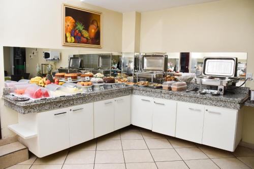 a buffet line with a lot of food at Hotel Casa Nova in Várzea Grande