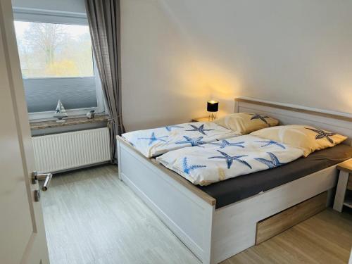 a bedroom with a large bed with a window at Haus Larum App. 5 in Scharbeutz