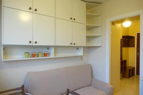 a living room with a chair and white cabinets at Song Festival apartment, 5-10 min from bus/airport in Tallinn