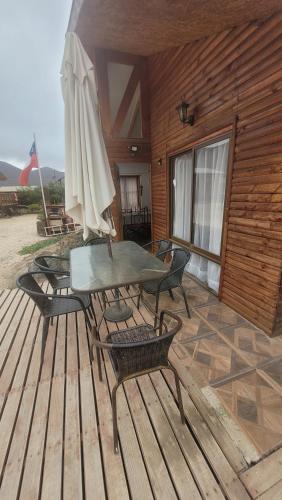 a patio with a table and an umbrella on a deck at Casas Rocamar in Totoralillo
