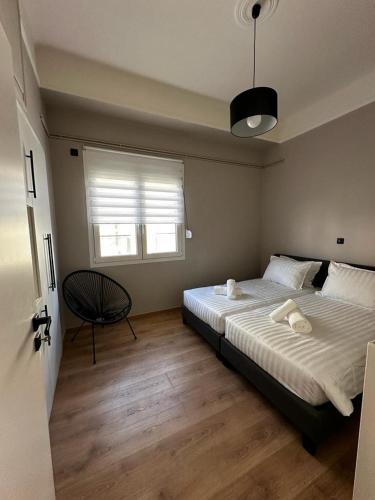 a bedroom with a bed and a chair and a window at Charmanta 23 in Nafplio
