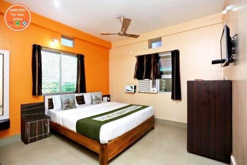 a bedroom with a bed with an orange wall at Goroomgo Krishna Residency Puri Best Seller in Puri