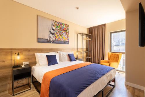 a hotel room with a bed and a chair at CONDE13 Lisboa - Superior Charm Apartments in Lisbon